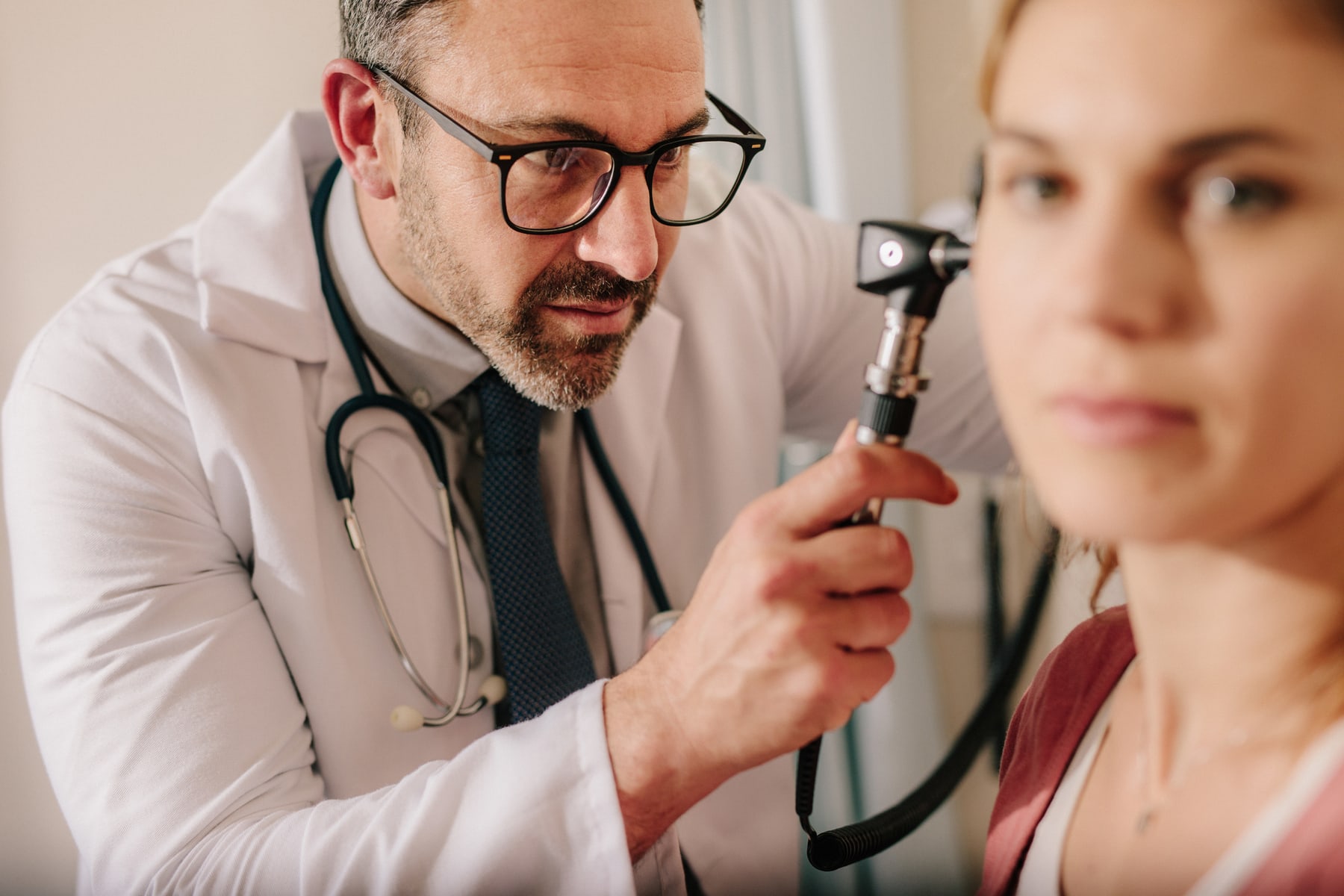 Clinician examining patient ear before hearing aid fitting