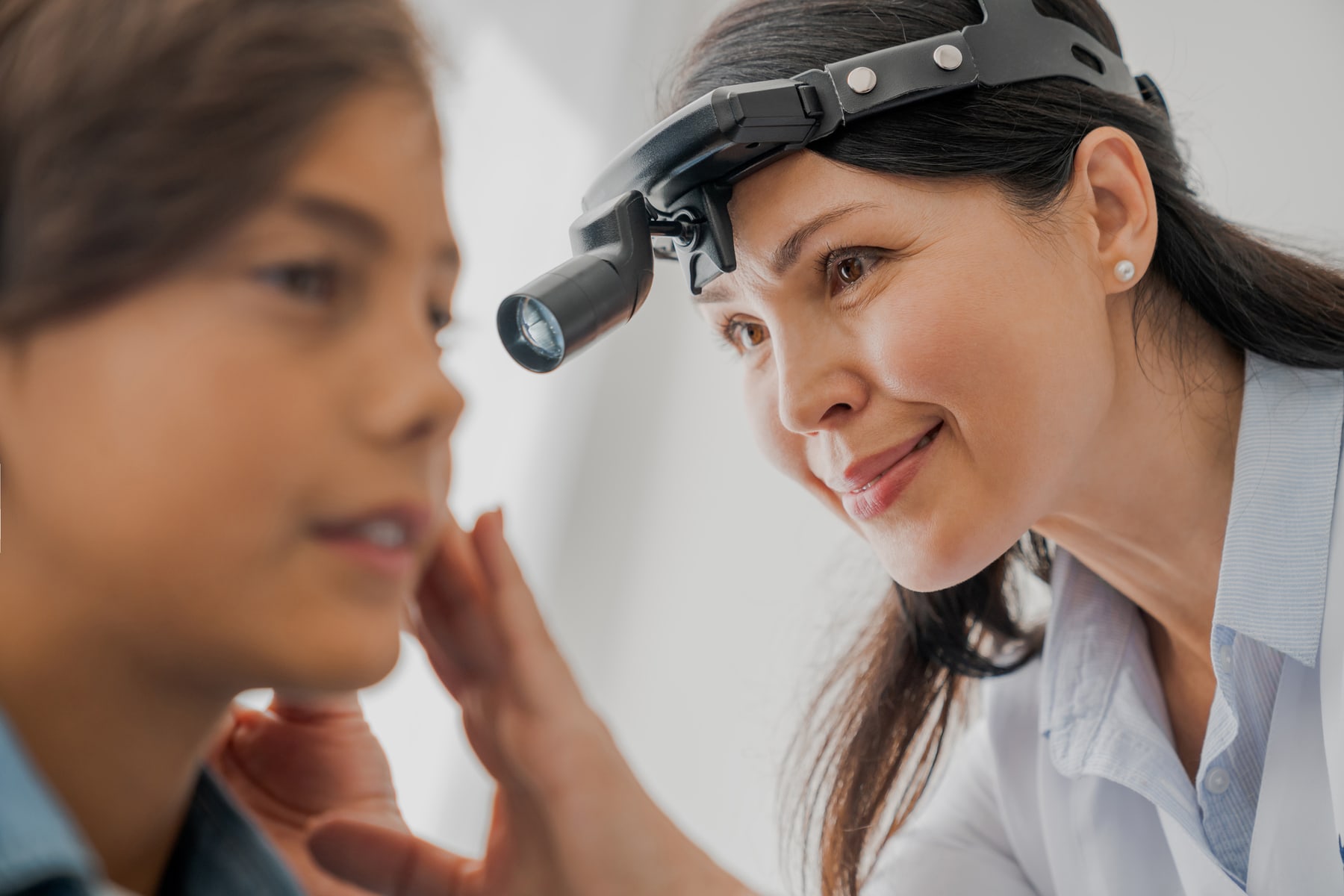 Audiologist examining a patient ear in clinic